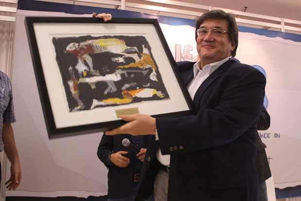 Jaime Abell o, director de la FNPI, muestra 'Los olvidados', un óleo original del pintor salvadoreño Óscar Soles, que fue la presea del recocimiento por parte de El Foro Centroamericano de Periodismo 2013 y El Faro. ﻿